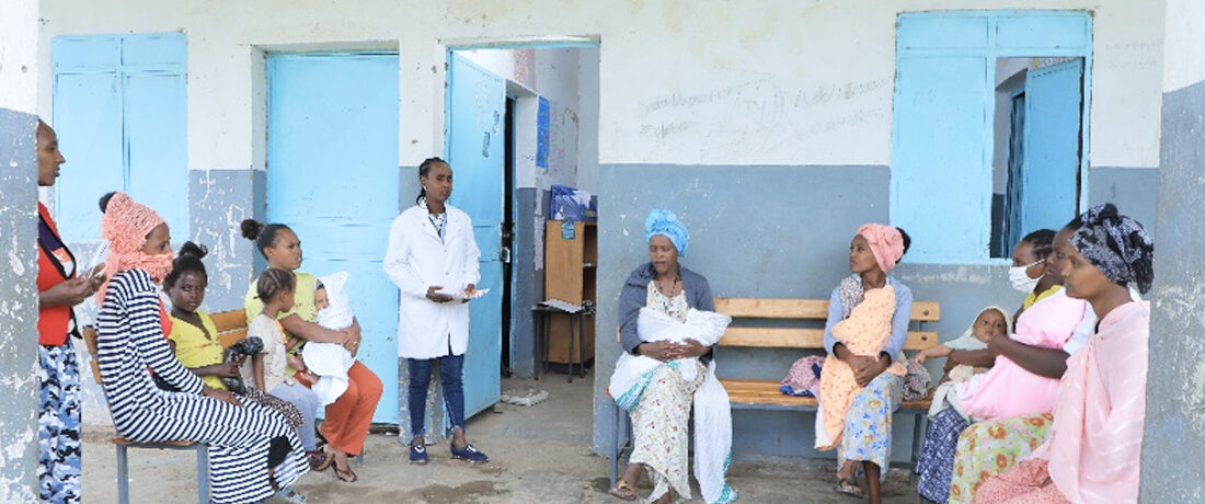 Health extension worker sitting with clients and having a discussion.