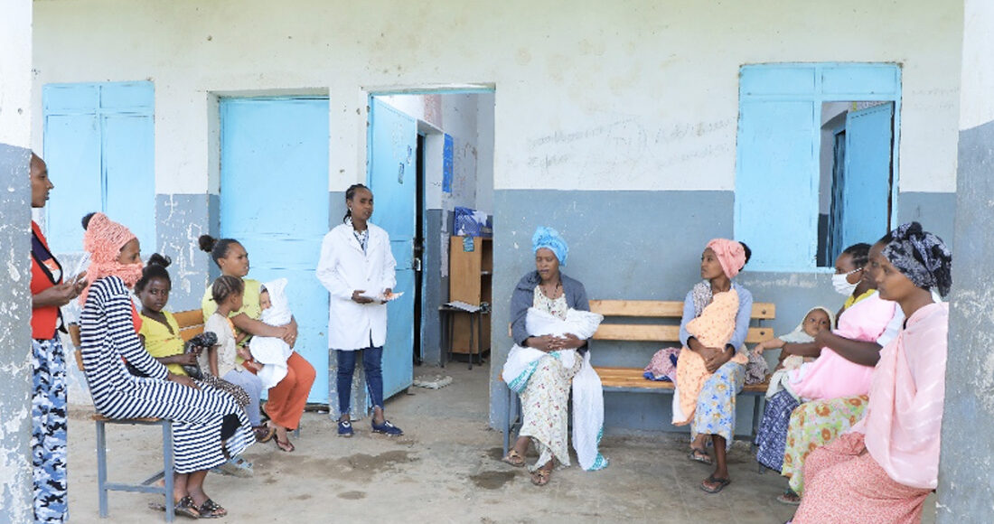 Health extension worker sitting with clients and having a discussion.