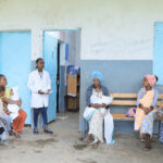 Health extension worker sitting with clients and having a discussion.