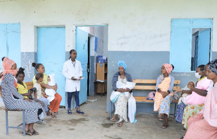 Health extension worker sitting with clients and having a discussion.