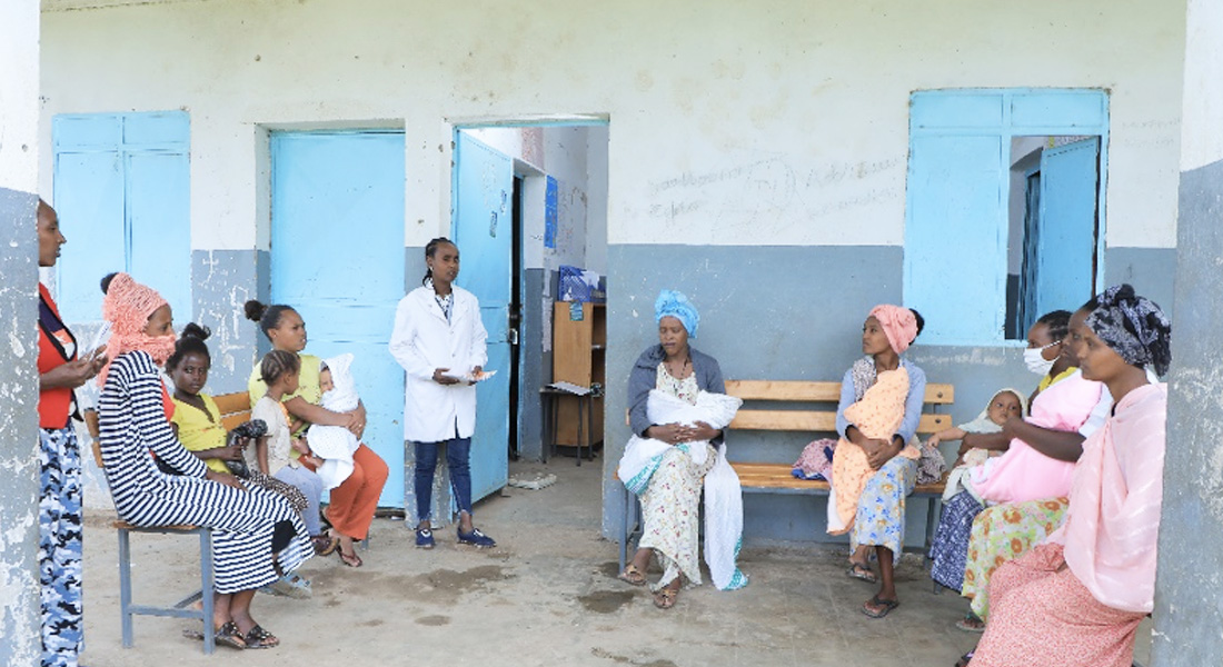 Health extension worker sitting with clients and having a discussion.