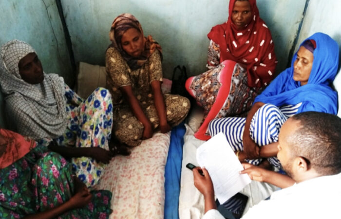 Health extension worker sitting with clients and having a discussion.