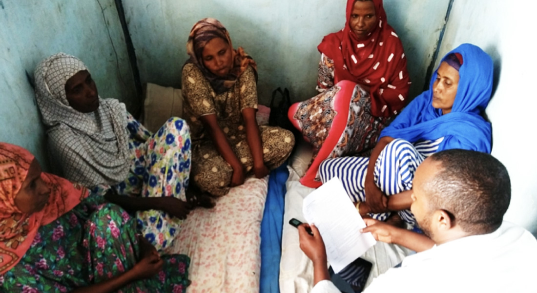 Health extension worker sitting with clients and having a discussion.